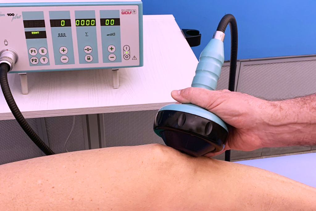 Apparecchio per onde d'urto in fisioterapia durante il trattamento di un ginocchio